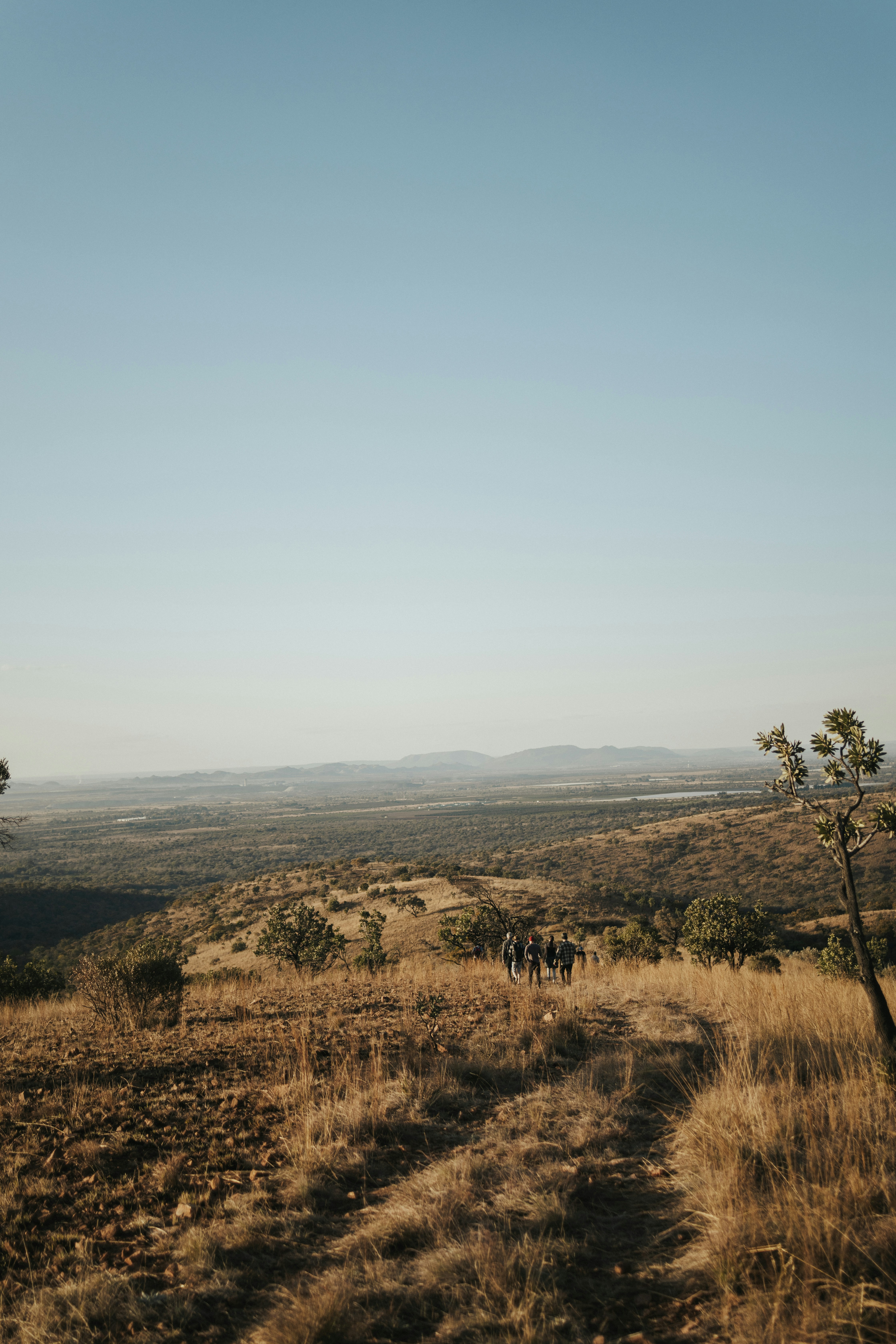 a group of people walking down a dirt road