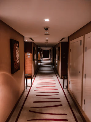 Sunlit hotel corridor with warm golden hues and soft shadows highlighting the boutique luxury ambiance.