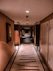 Modern hotel hallway with ambient lighting leading to rooms