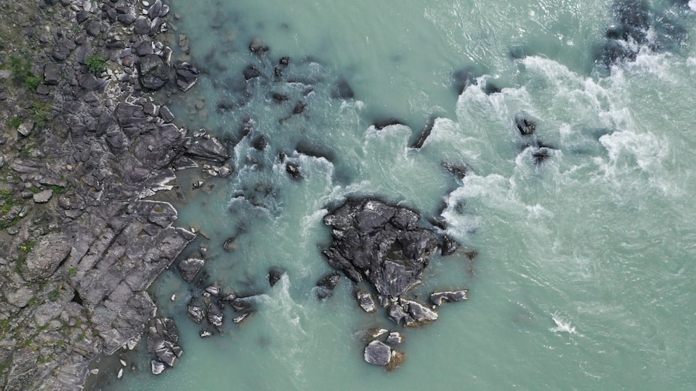 a bird's eye view of some rocks in the water