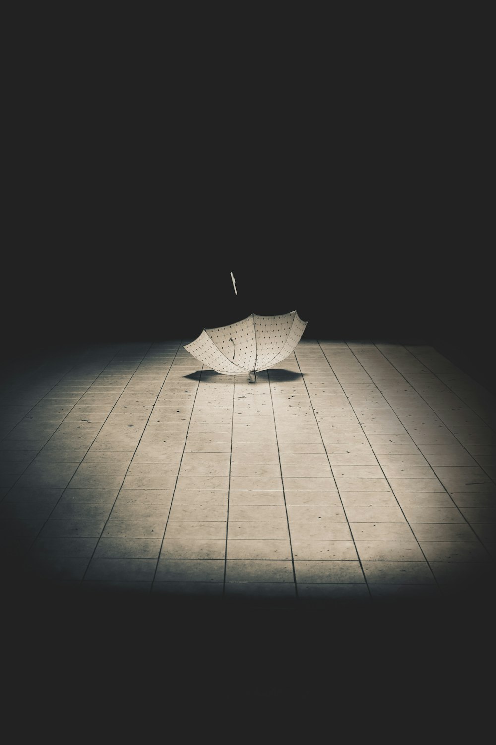 a white umbrella sitting on top of a wooden floor