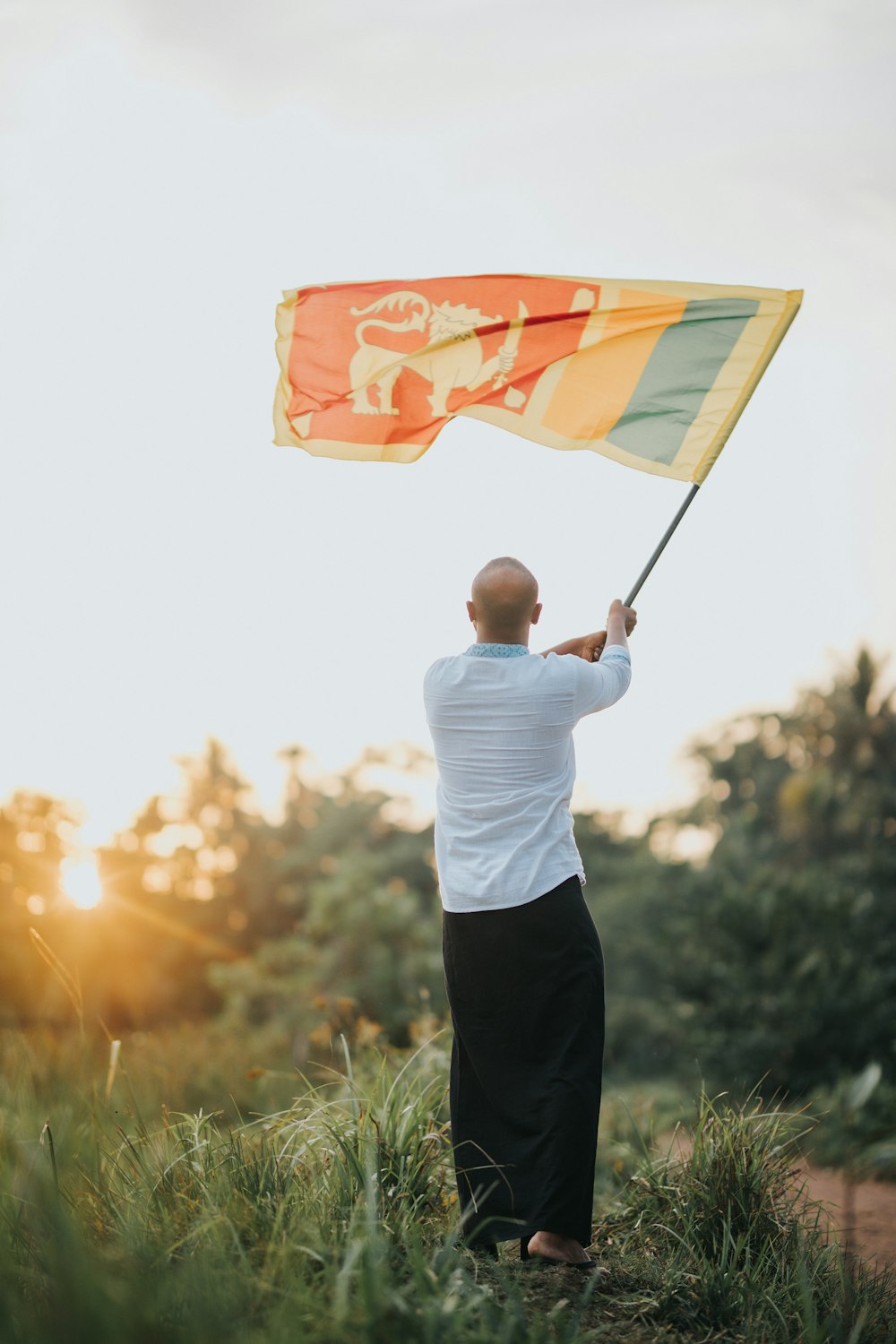 a man holding a flag while standing in a field