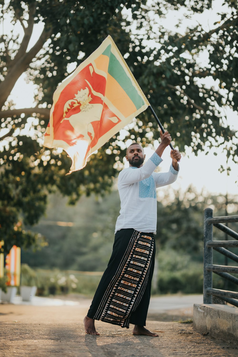 a man holding a flag on a dirt road