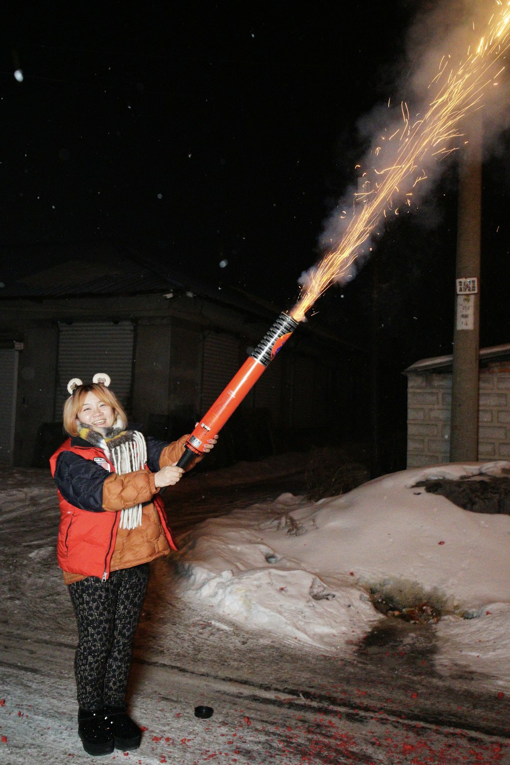 a woman holding a sparkler in the snow