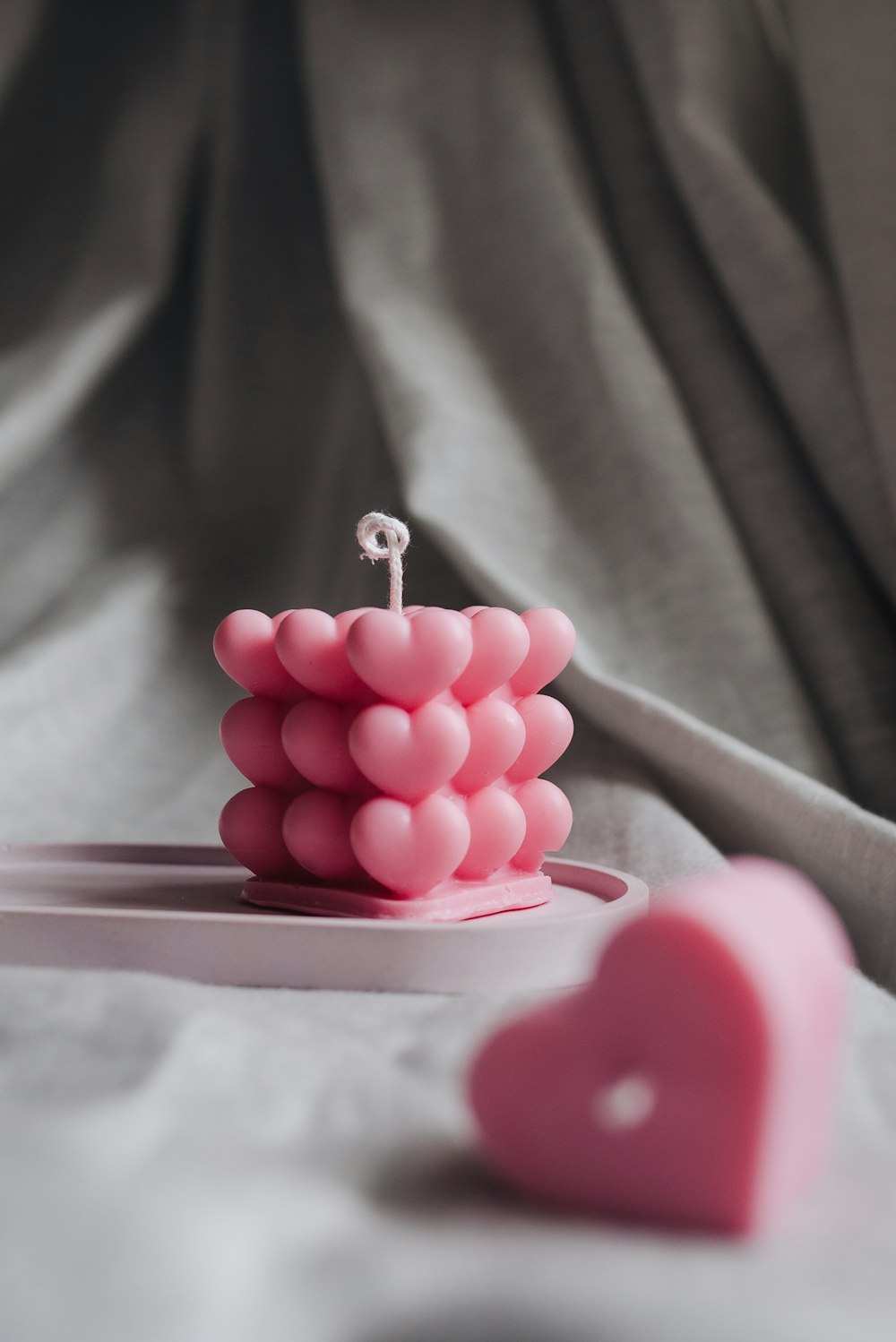 a close up of a pink object on a bed