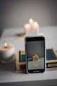 a cell phone sitting on top of a table next to a candle