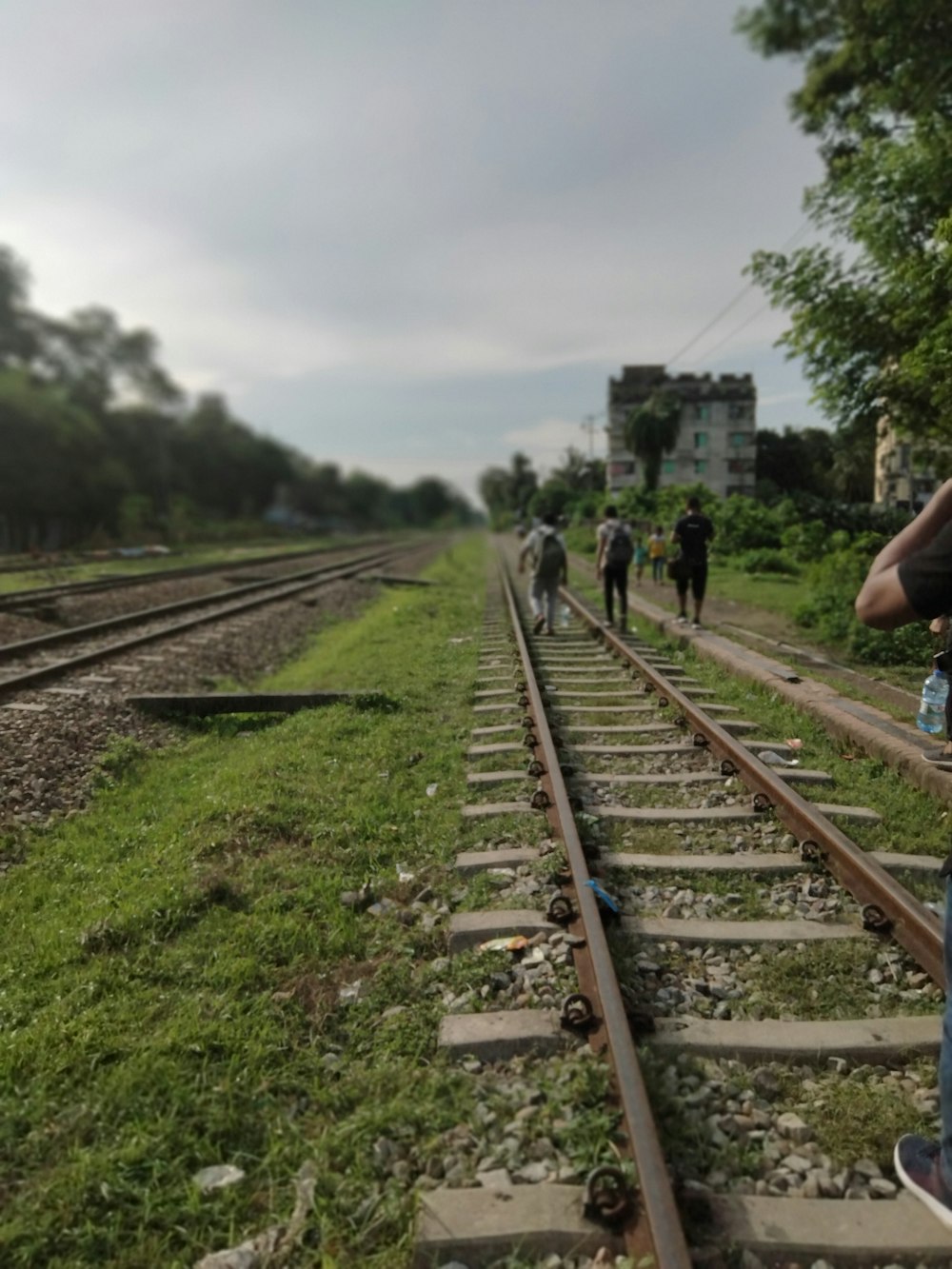 a group of people walking down a train track