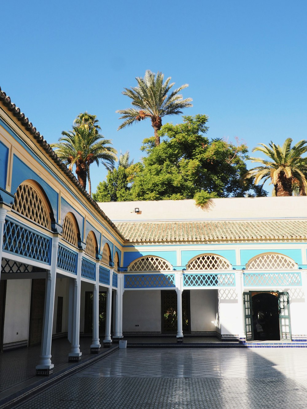 El patio de un edificio con palmeras al fondo