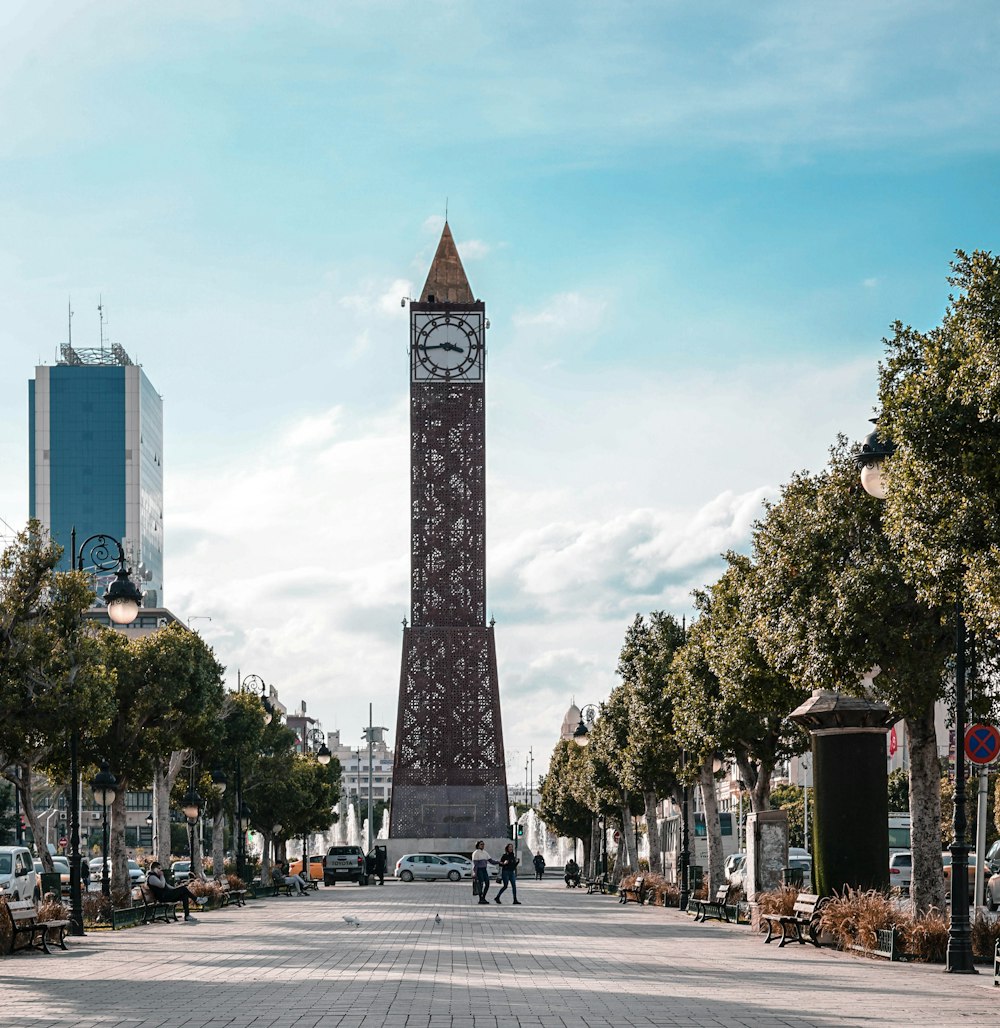 a tall clock tower sitting on the side of a road