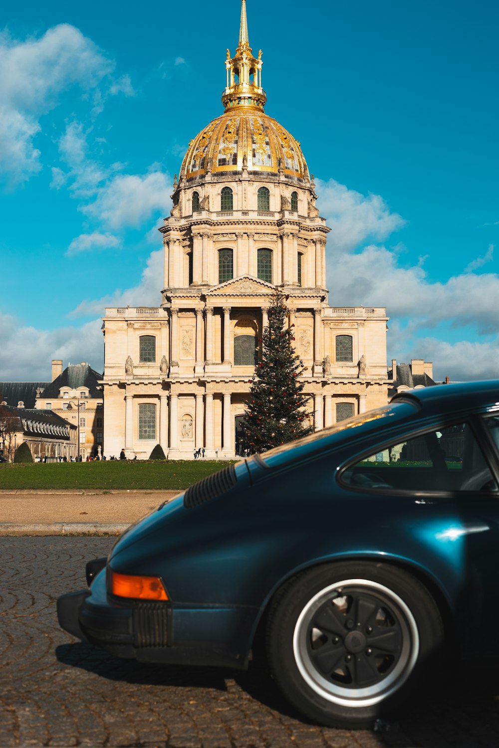 a blue car parked in front of a large building