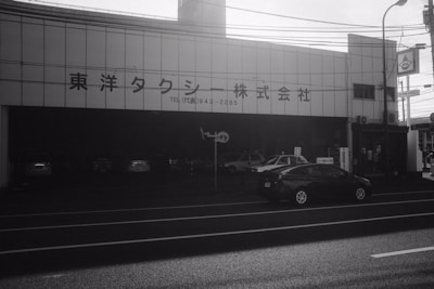 Wide shot of the JP Car storefront with signage and parked cars outside.