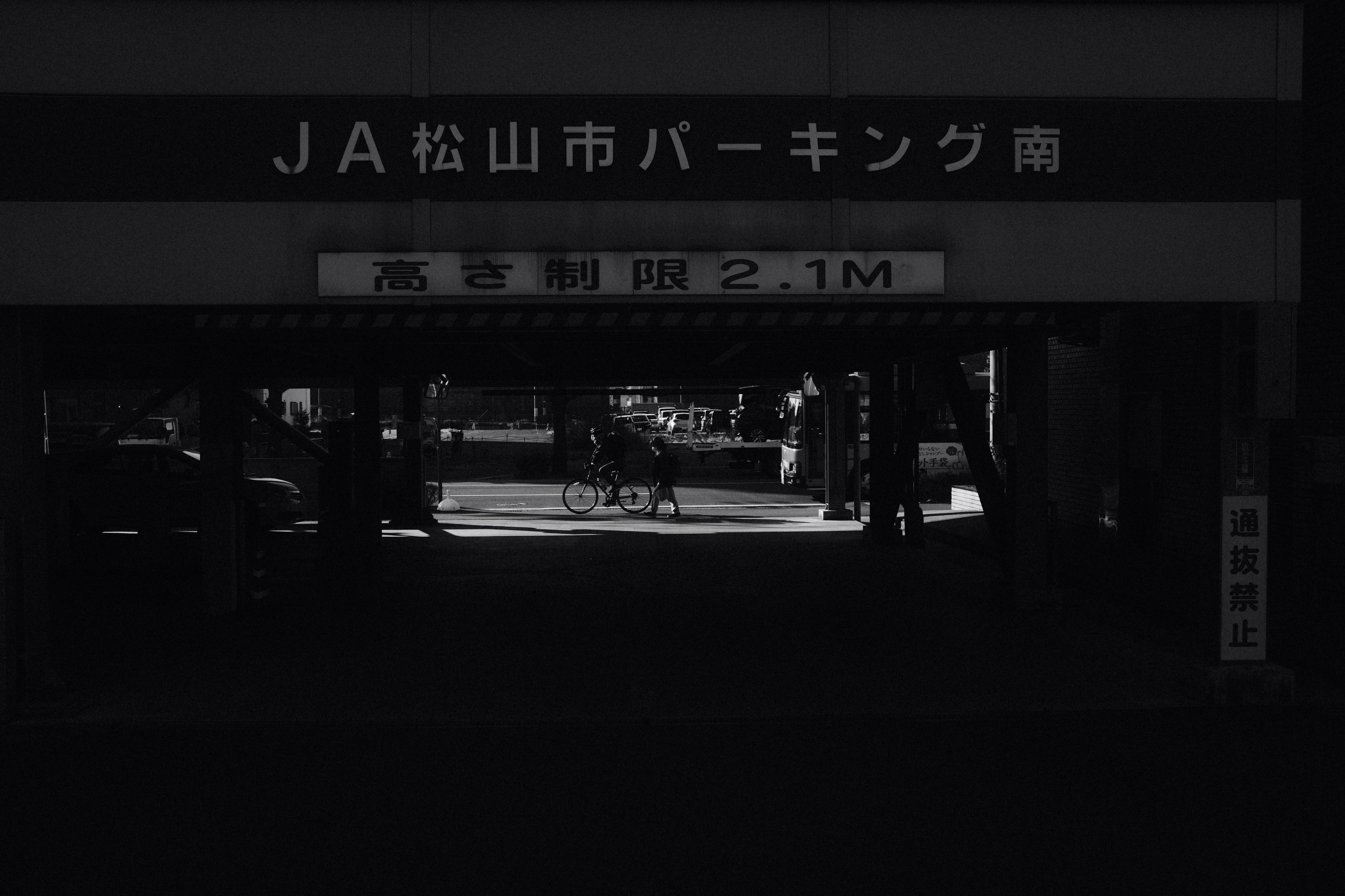 a black and white photo of a person riding a bike