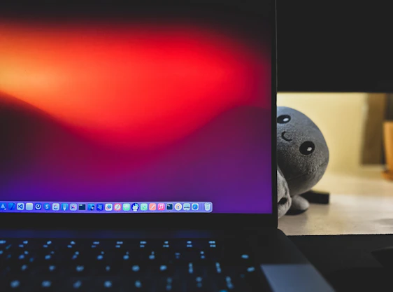 A friendly person using a laptop with colorful tool icons floating around the screen.