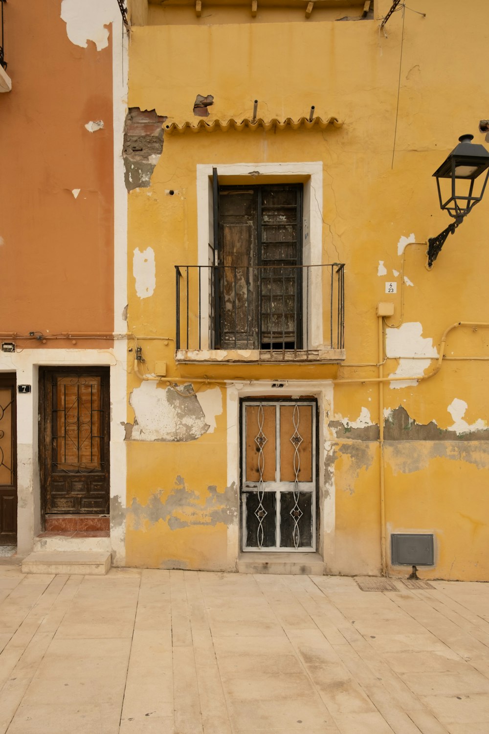 un edificio amarillo con dos puertas y una luz en el lateral