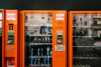 an orange vending machine with sodas in it