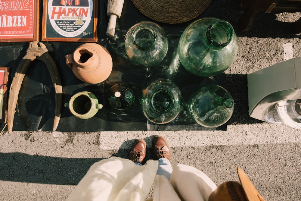 a person laying on the ground next to a bunch of vases