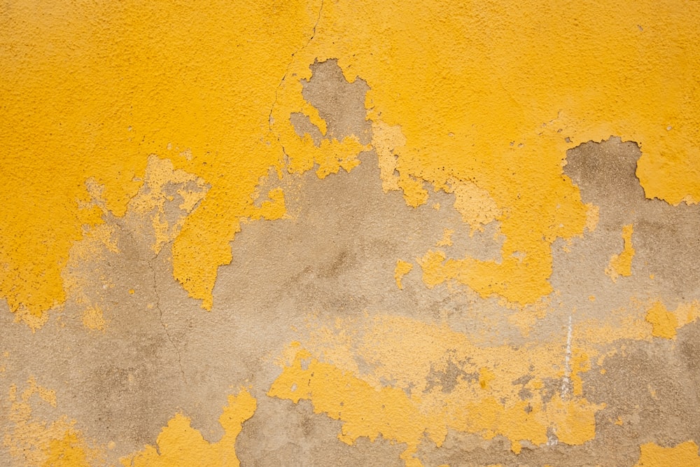 a yellow and gray wall with peeling paint