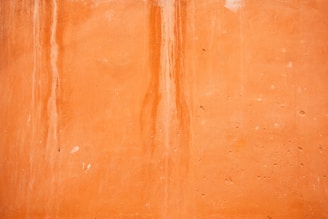 an orange wall with a clock on it