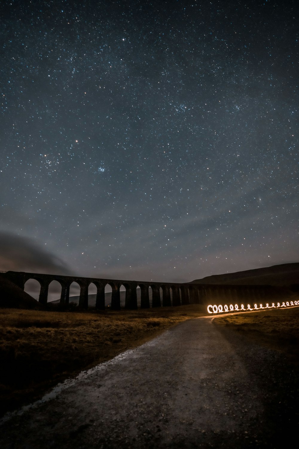 Un treno che viaggia su un ponte sotto un cielo notturno