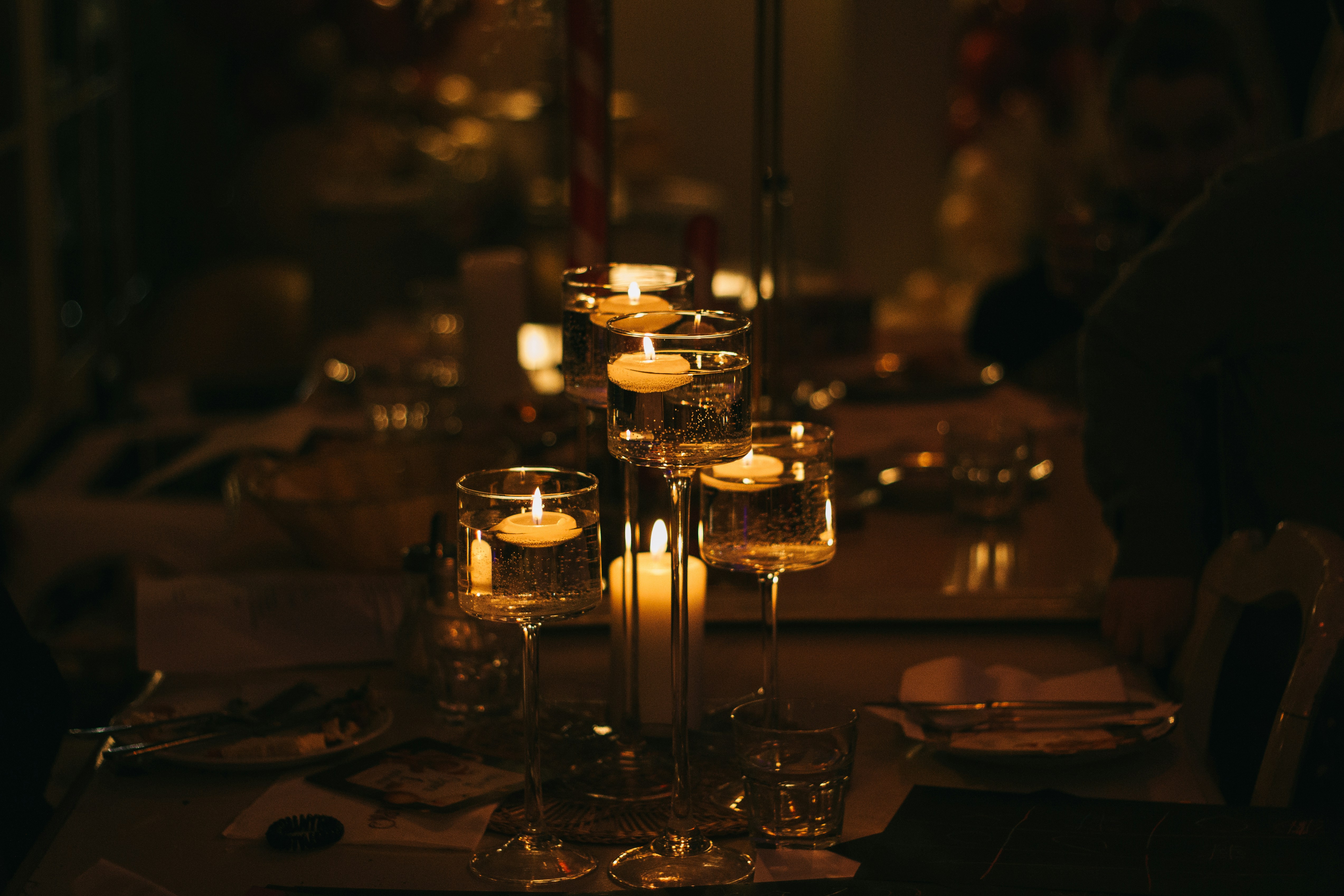 a table topped with lots of glasses filled with candles