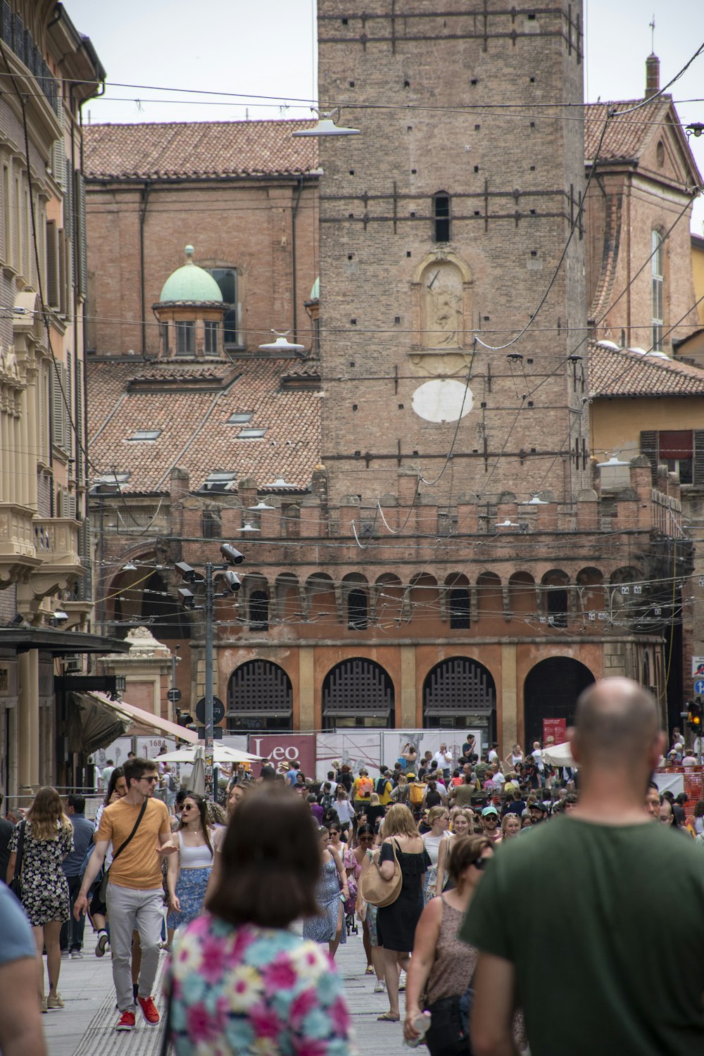 a crowd of people walking down a street next to tall buildings