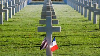 a cemetery with rows of crosses and flags
