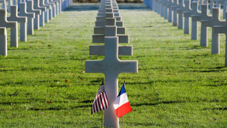 a cemetery with rows of crosses and flags