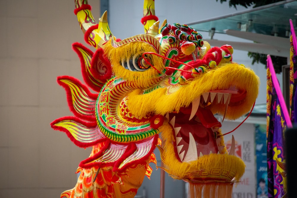 a yellow dragon statue with red and green decorations