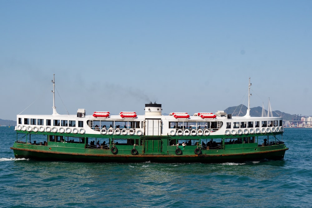 a green and white ferry boat in the water
