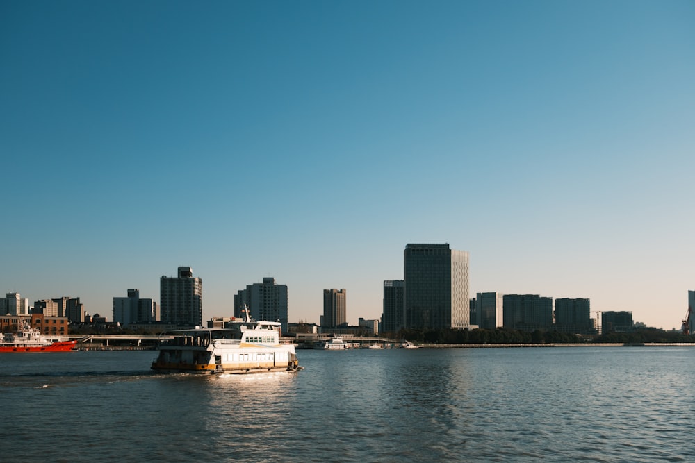 a boat traveling down a river in front of a city