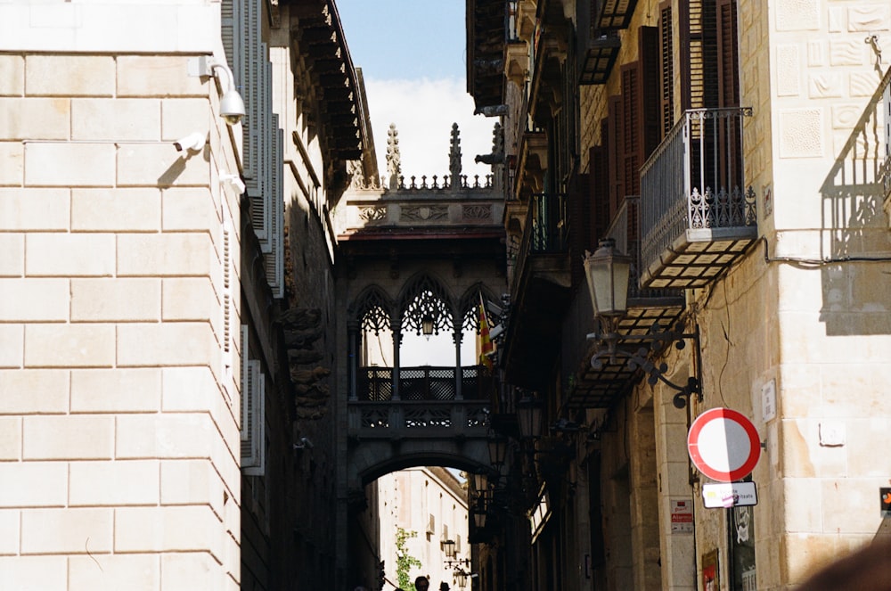 a narrow city street with a bridge in the background
