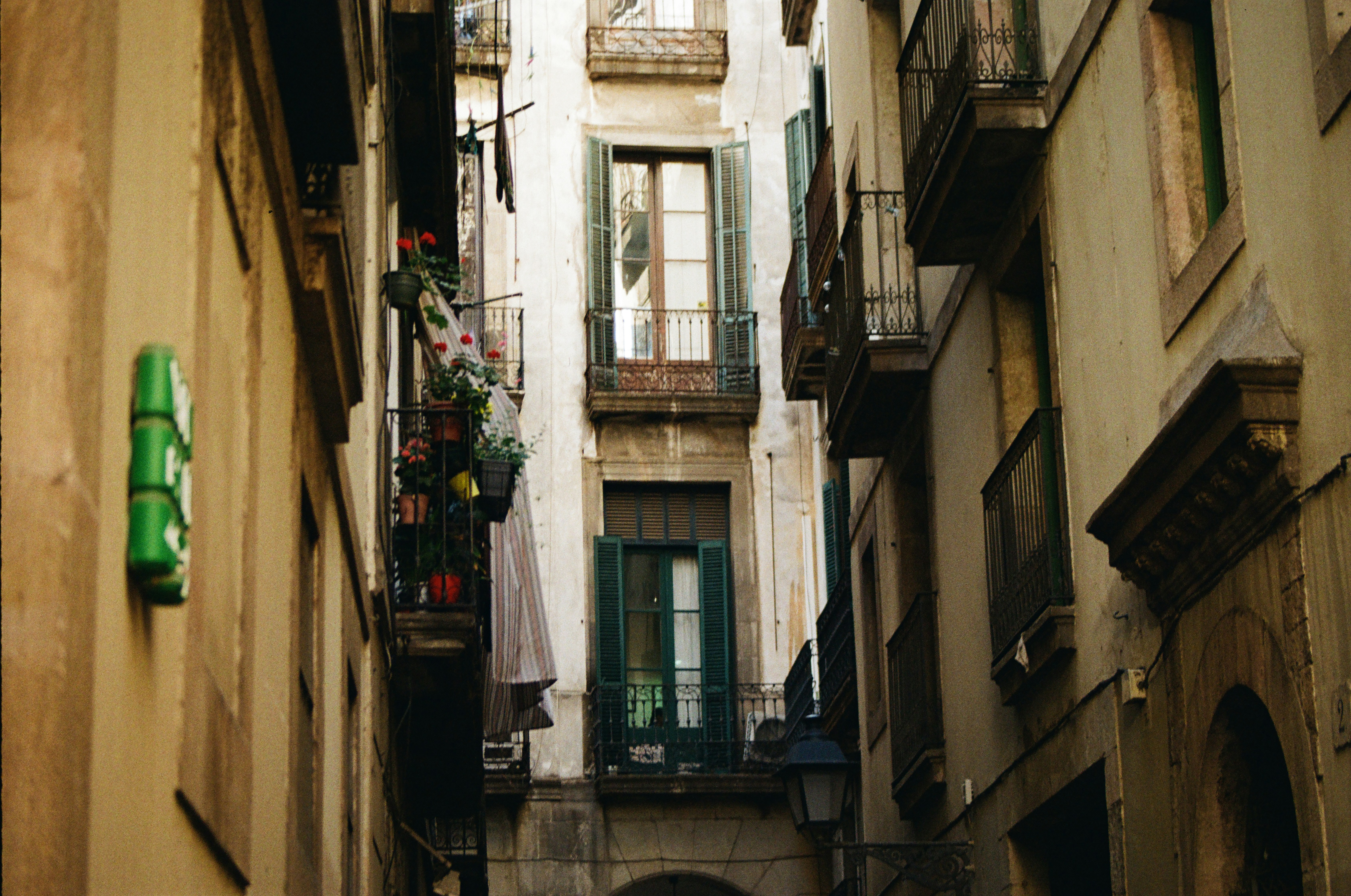 a narrow alleyway in a city with balconies, 