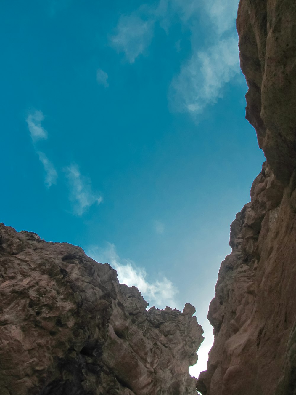 Una persona parada en la cima de un acantilado rocoso