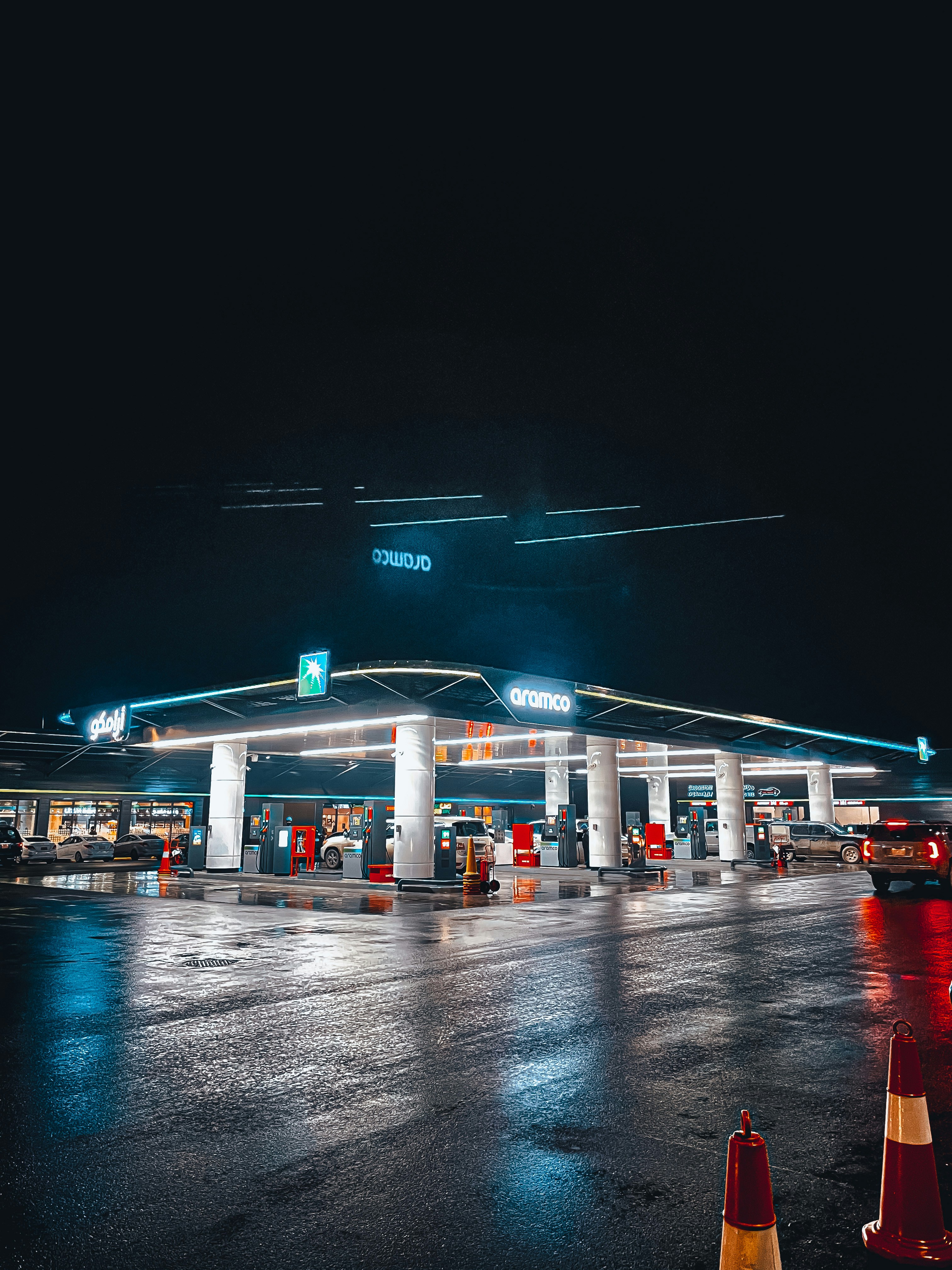 A gas station at night with traffic cones in the foreground photo