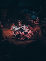 A nomadic campfire scene with pottery and tools resting nearby.