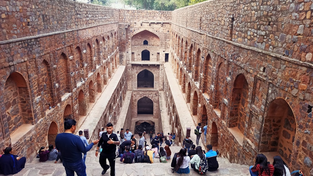 a group of people standing around a stone building