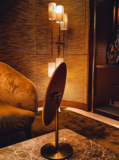 A sleek, modern living room illuminated by warm, elegant architectural lighting highlighting textures and shapes.