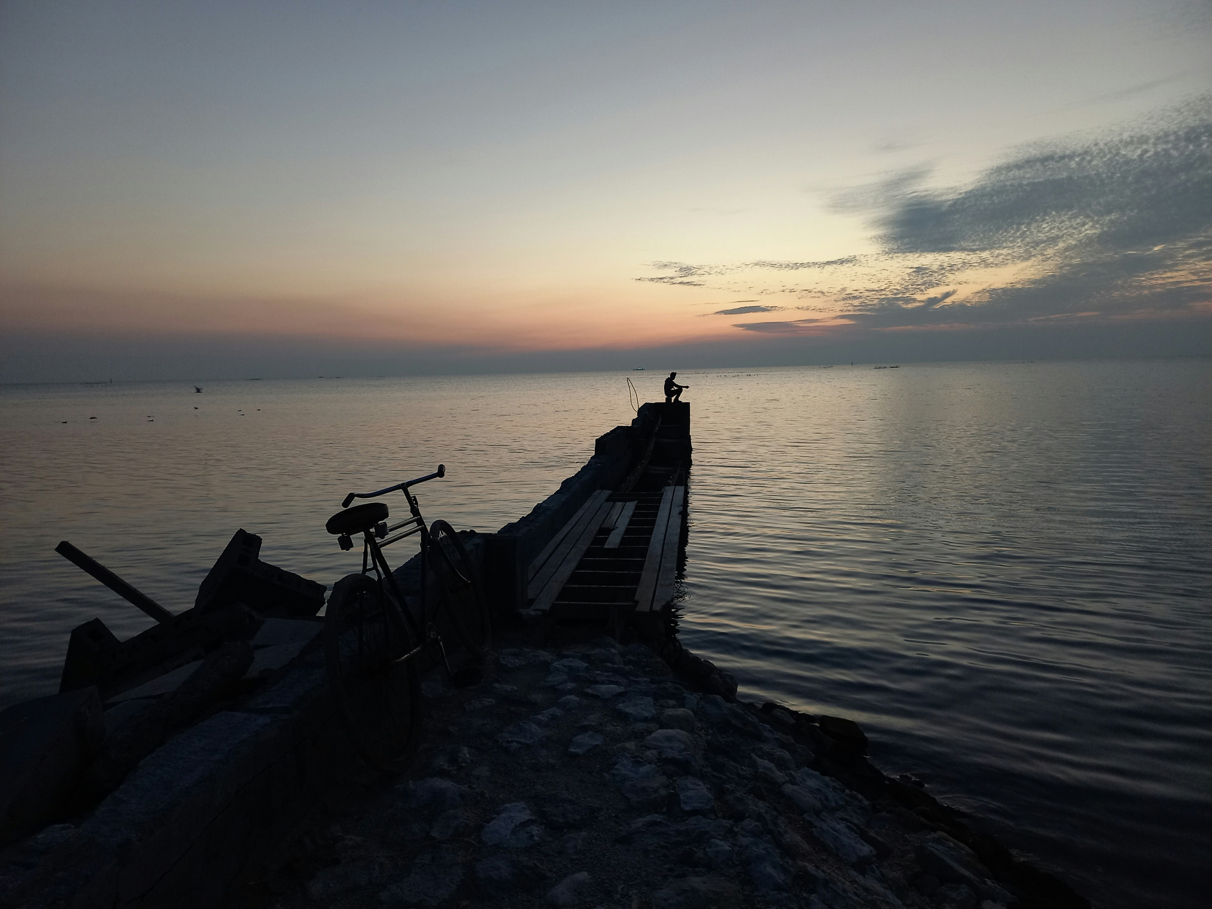 a bike is parked on the edge of a pier