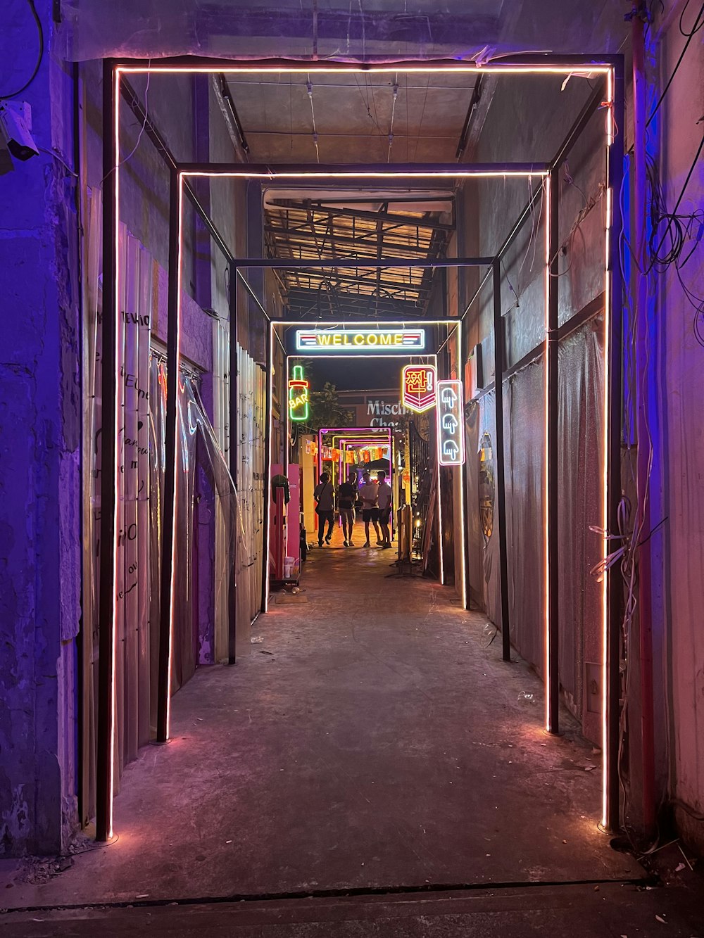 a long hallway with neon lights on the sides of it