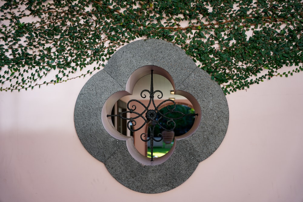 a circular mirror on a wall with a wrought iron frame