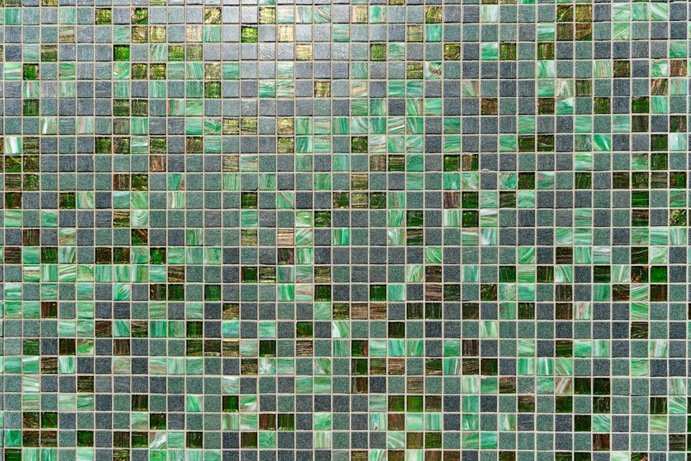 a close up of a tiled wall with green and brown tiles