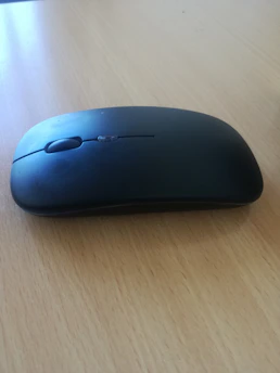 Ergonomic wireless mouse with matte black finish displayed on white surface