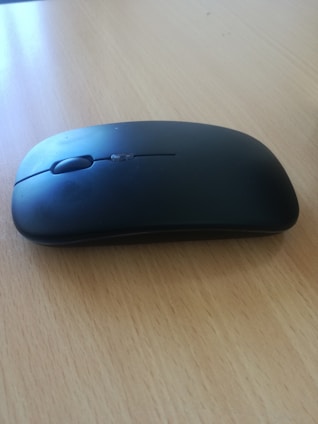 Close-up of a stylish wireless mouse with matte finish on a concrete surface