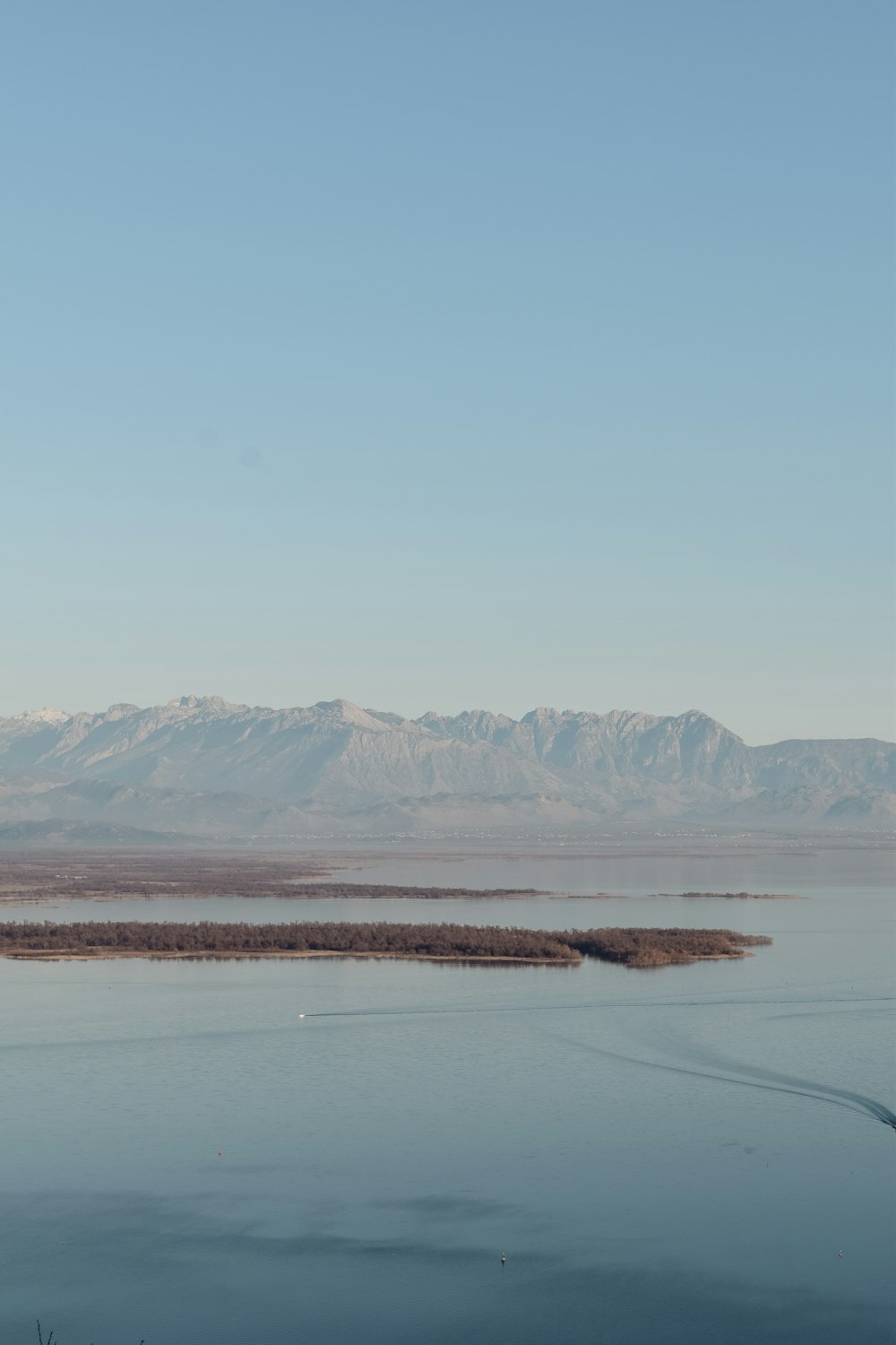 a large body of water with mountains in the background