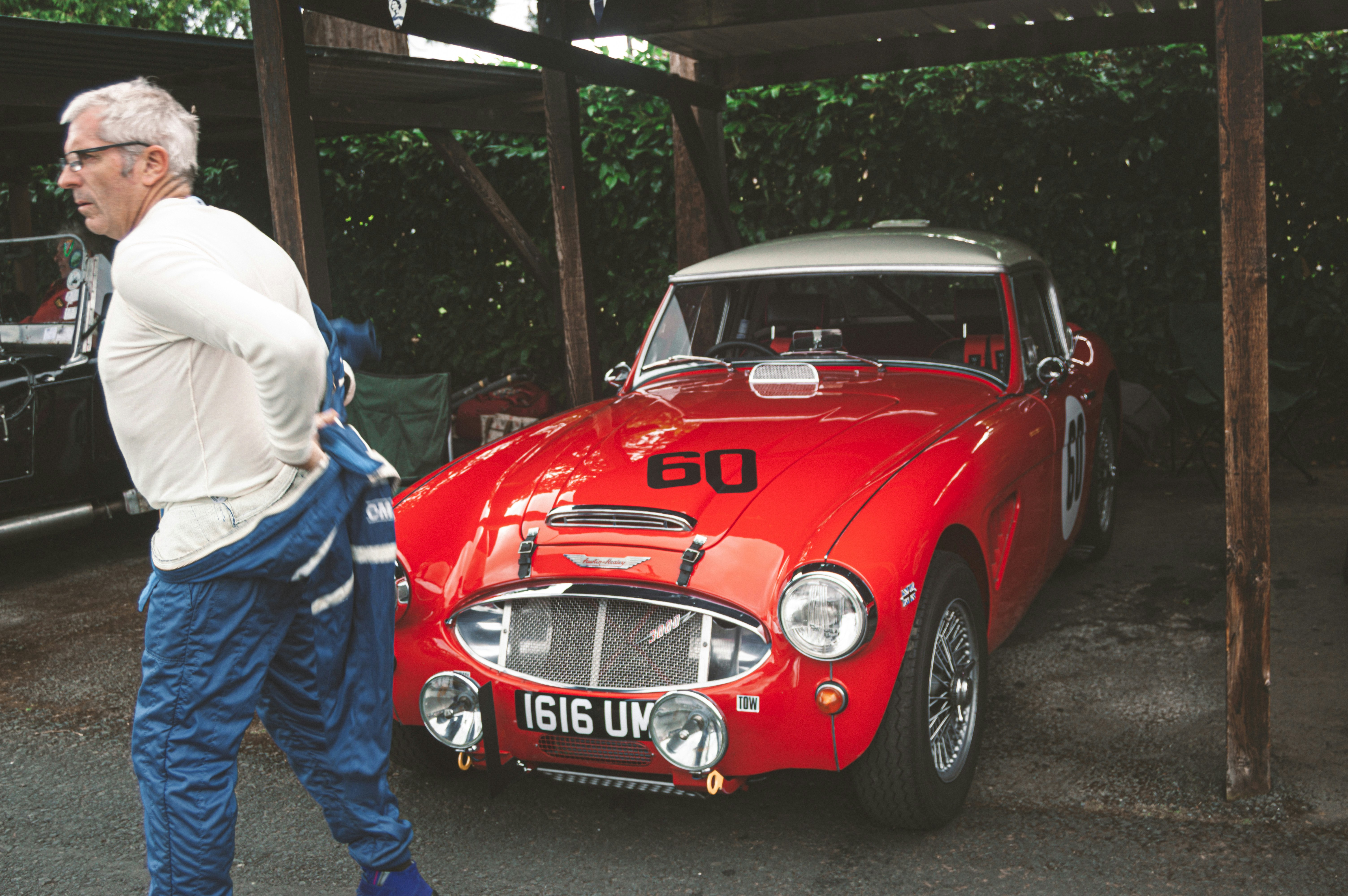 a man standing next to a red sports car