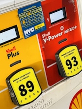 Two gasoline pump options showing Shell Plus with an octane rating of 89 and Shell V-Power Nitro+ with an octane rating of 93. A blue inspection sticker for NYC Consumer Affairs is displayed, covering the years from 2020 to 2024.