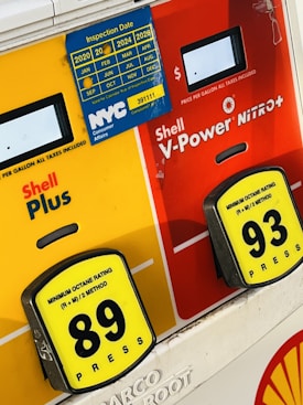 Two gasoline pump options showing Shell Plus with an octane rating of 89 and Shell V-Power Nitro+ with an octane rating of 93. A blue inspection sticker for NYC Consumer Affairs is displayed, covering the years from 2020 to 2024.