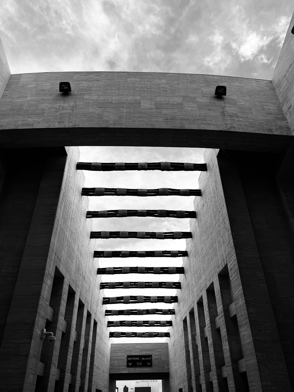 a black and white photo of a walkway between two buildings