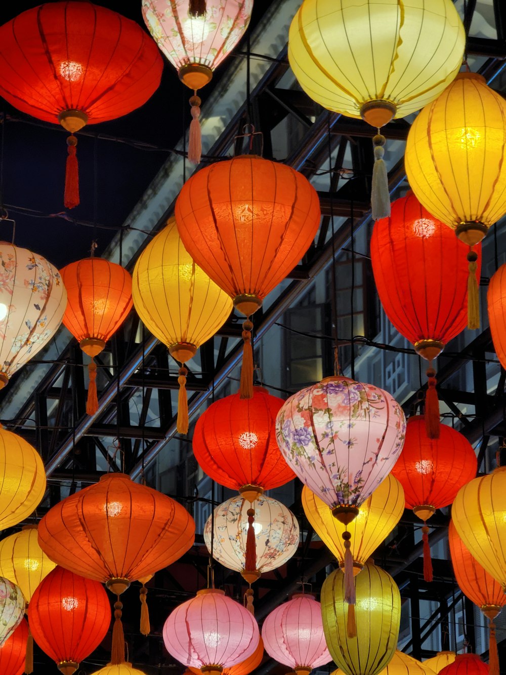 a bunch of colorful lanterns hanging from a ceiling