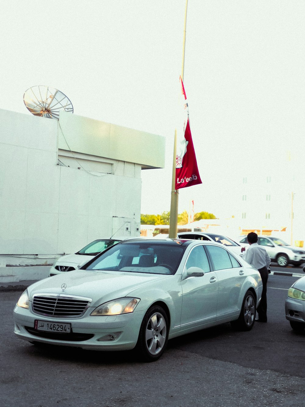 a white car parked in a parking lot next to a building